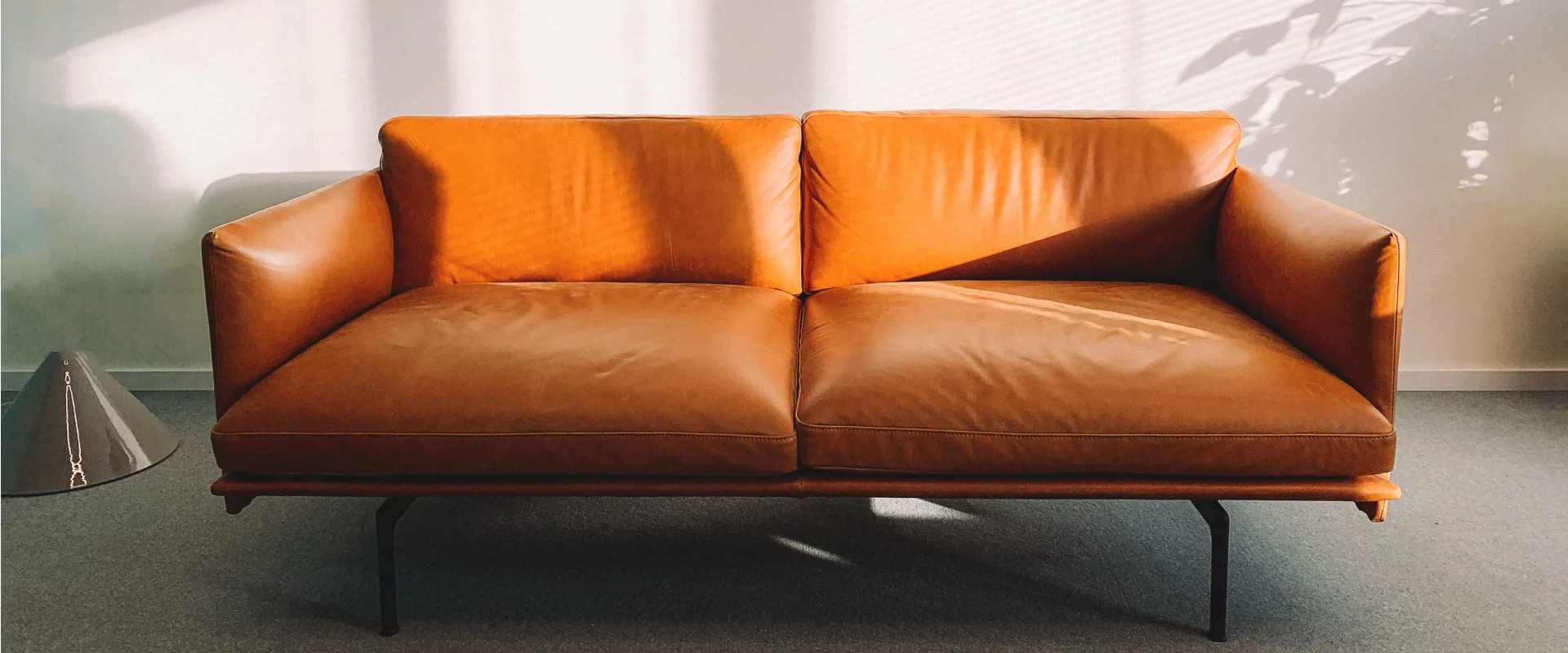 Photo of orange couch in a muted space ready to be decorated