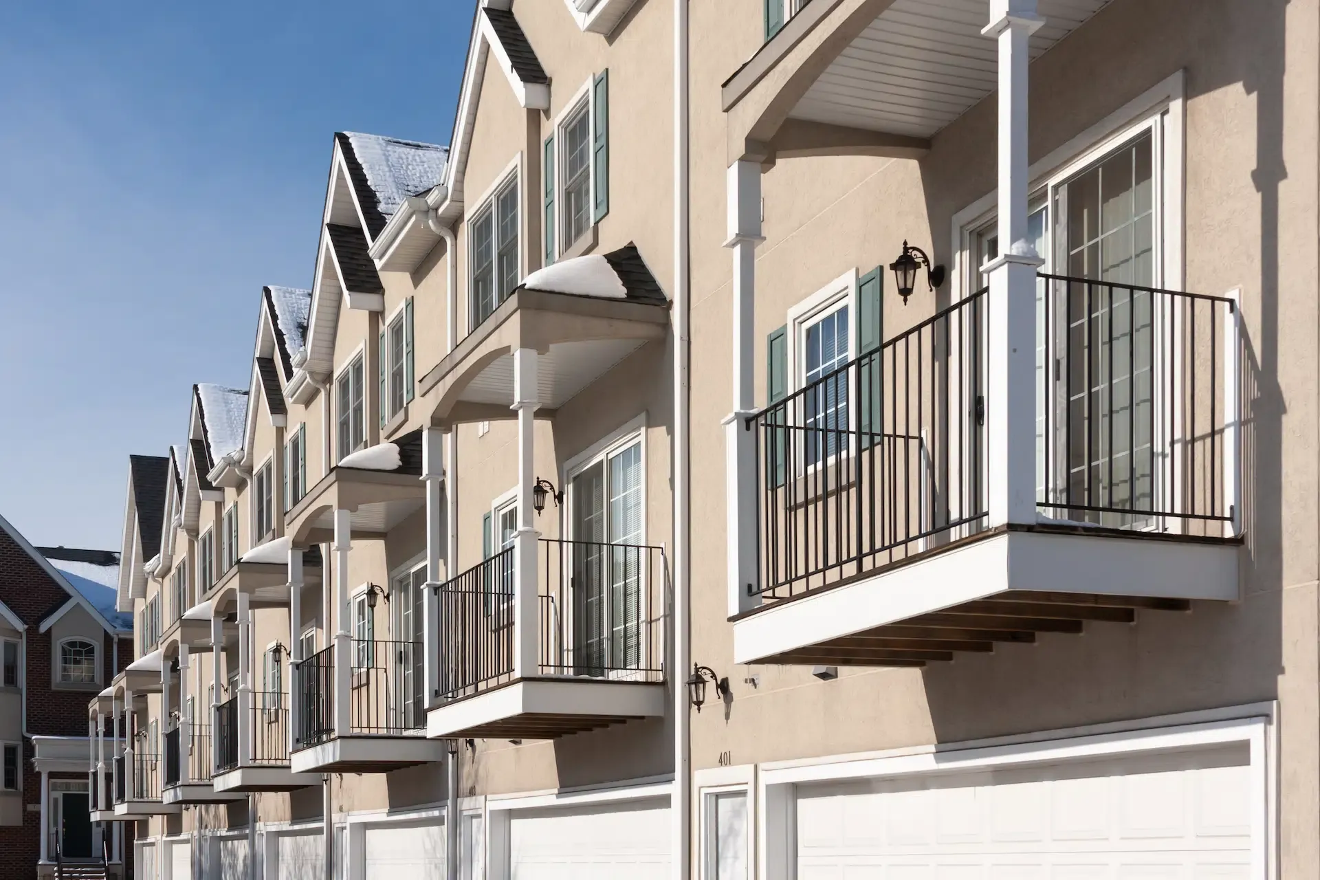 A row of apartment condominiums with balconies and garages, representing multi-unit residential property management in Alaska.