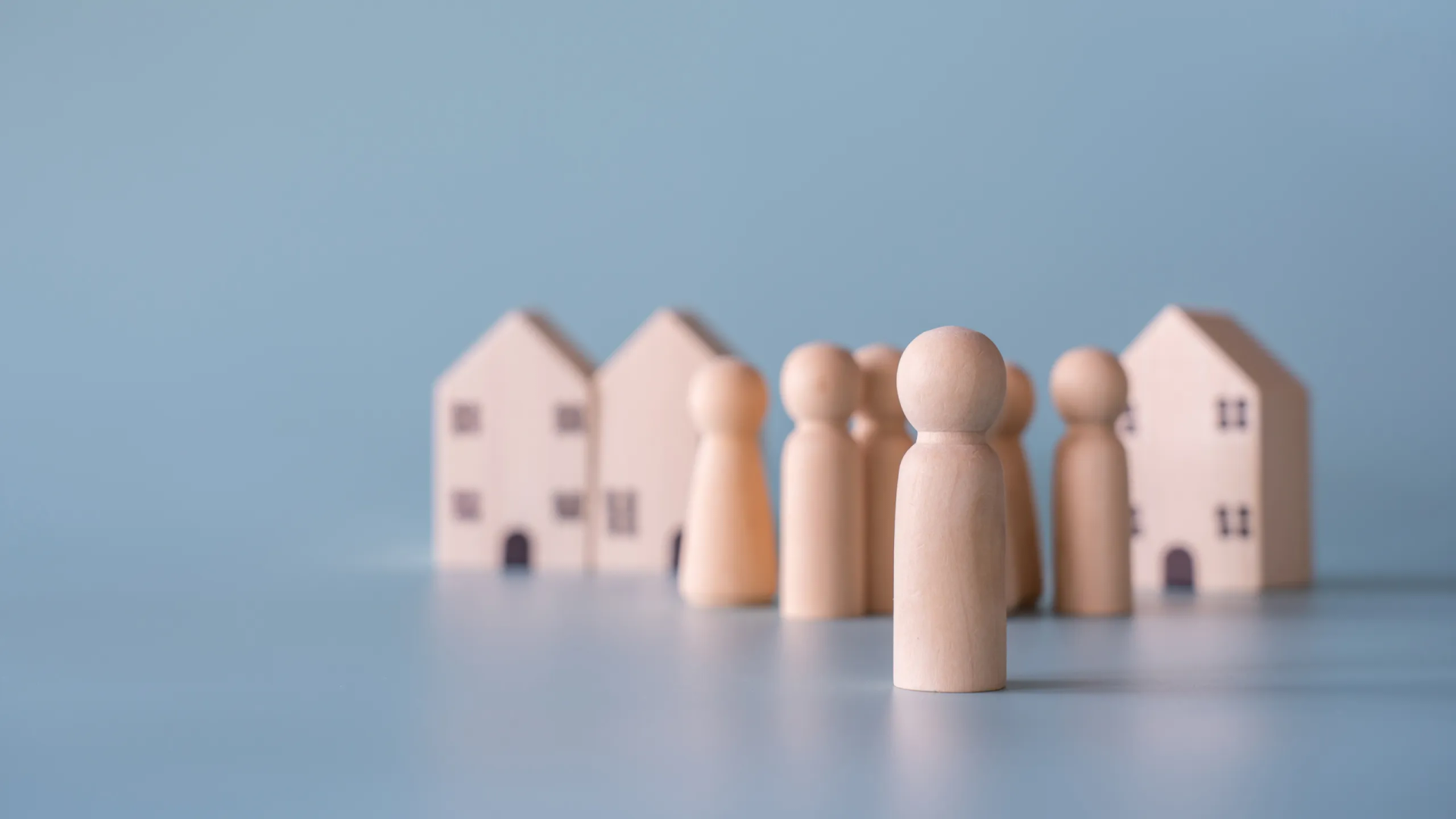 Small wooden faceless figures of a human family.