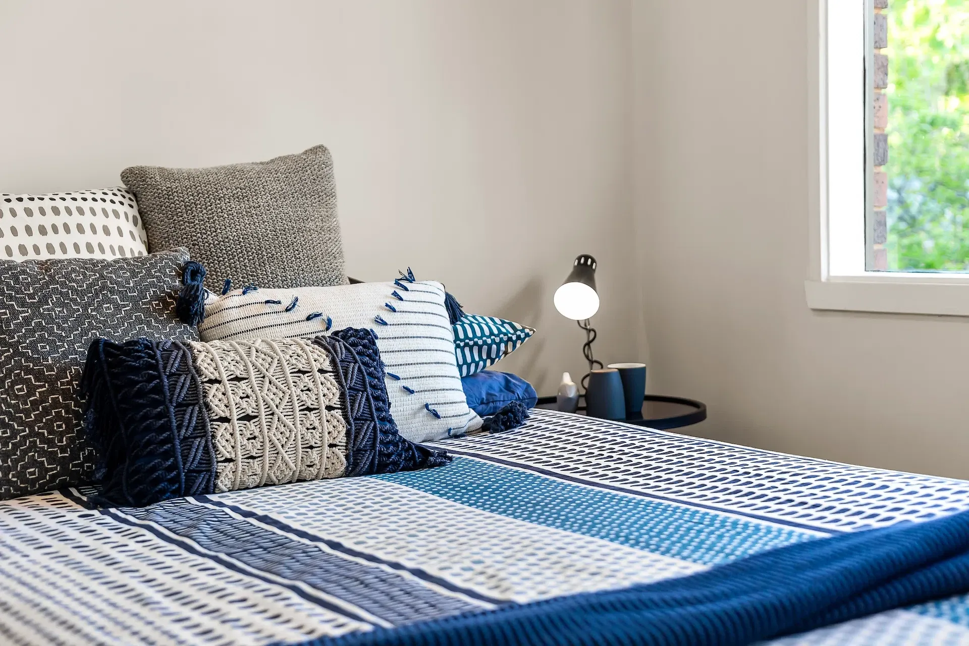 Decorative pillows and comforter on a bed — turnkey rental ready